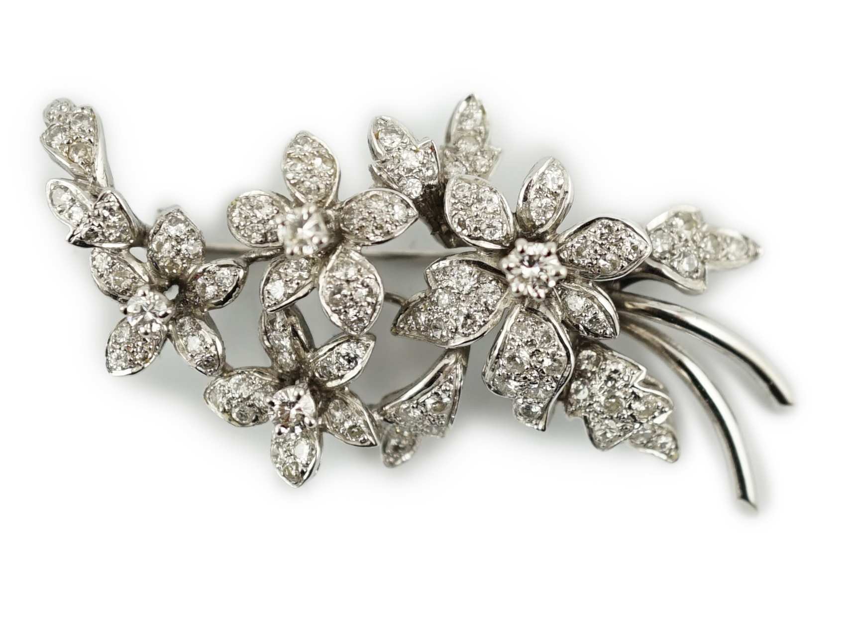 A late 1960's 18ct white gold and diamond cluster set floral spray brooch